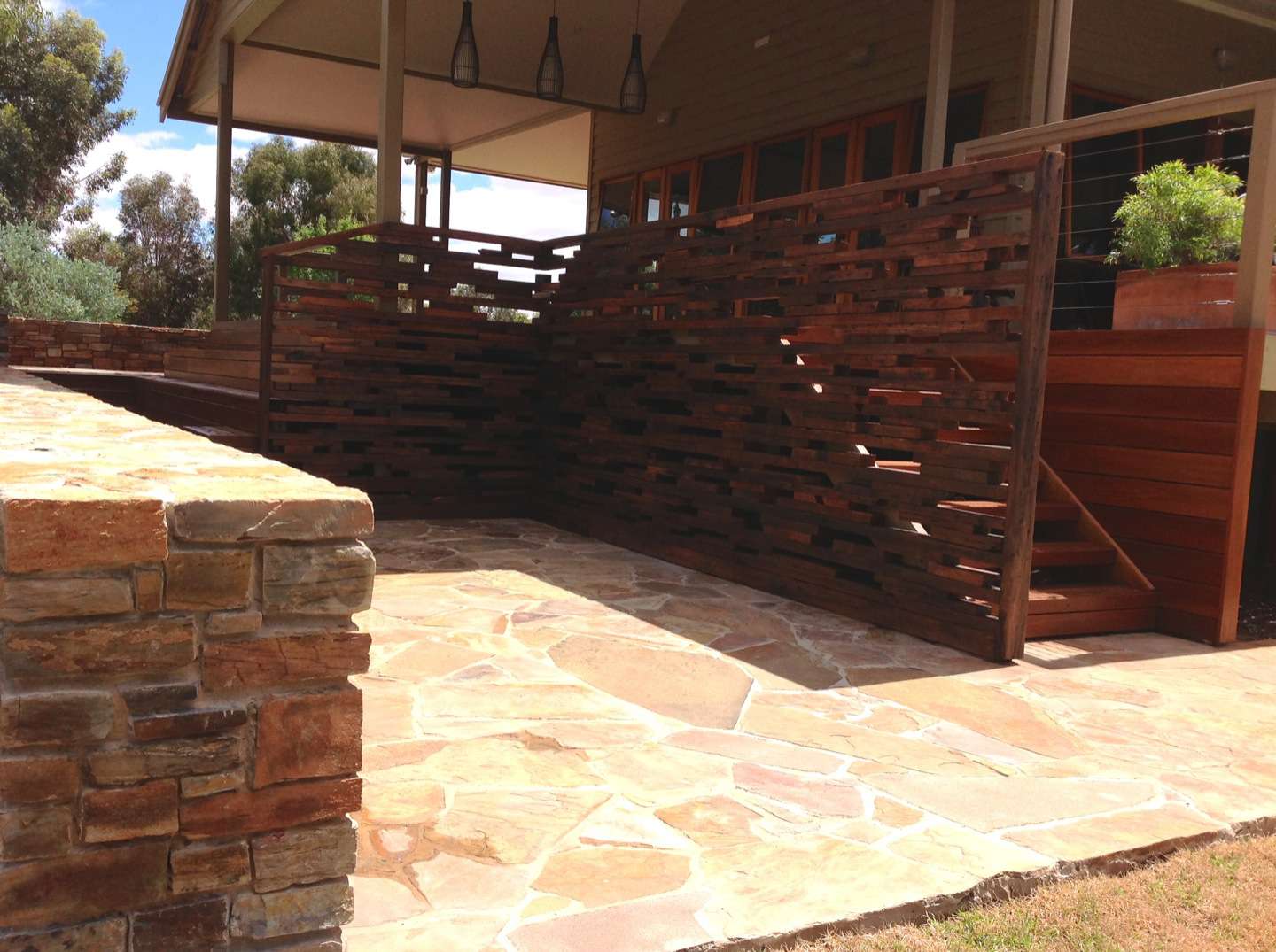 Stone work complemented by reclaimed hardwood screen